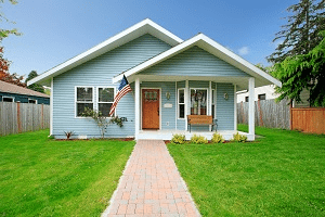 Photograph of a blue house and the front yard.