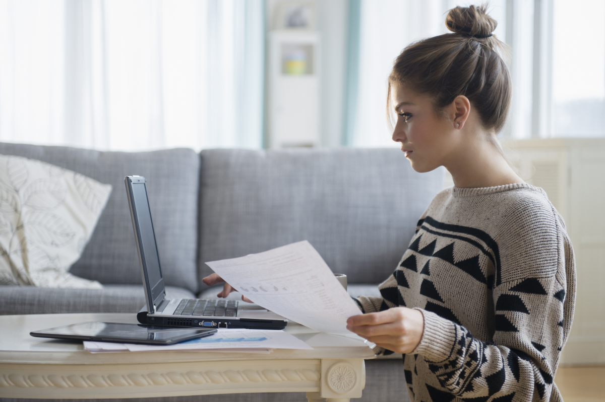 Photo of person working on laptop in a living room.