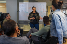 People working together near a whiteboard in a conference room.