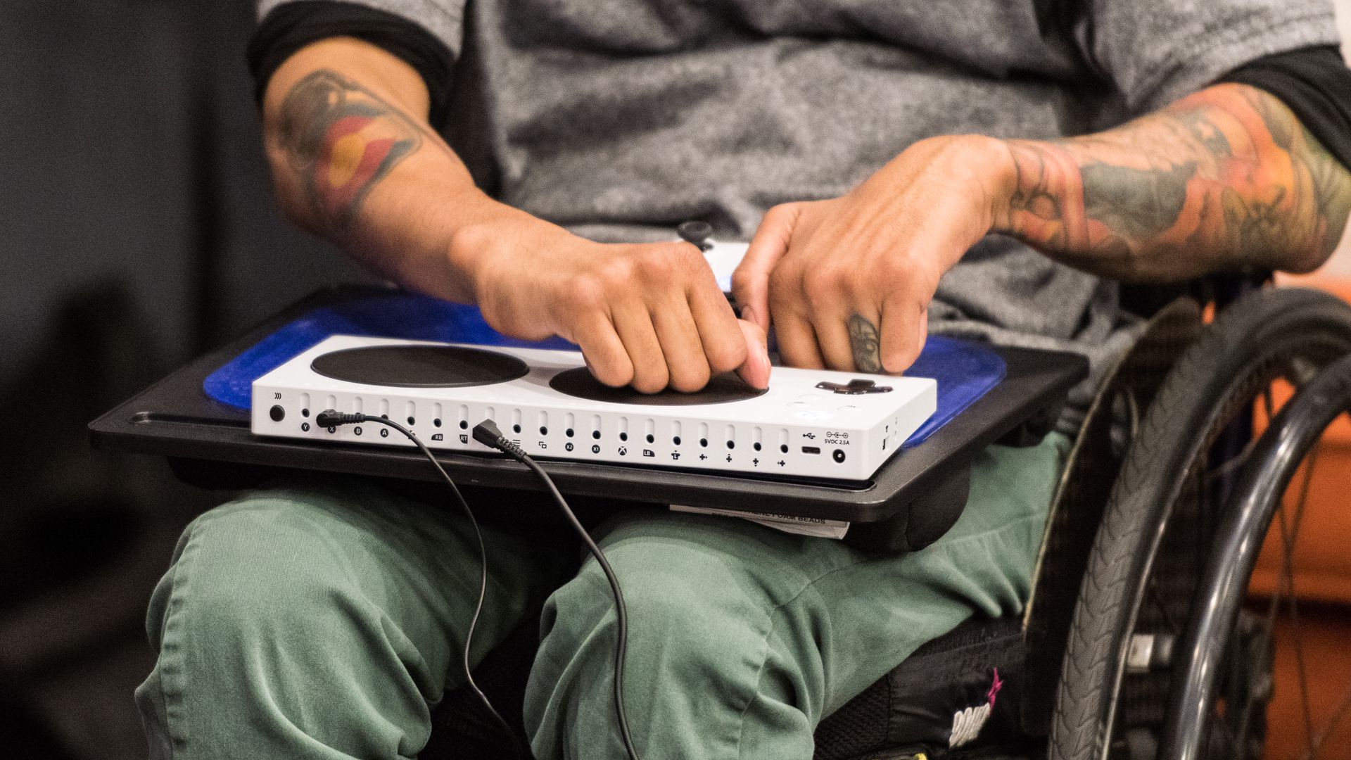 An image of a player in a wheelchair using an Xbox Adaptive Controller on a lap board.