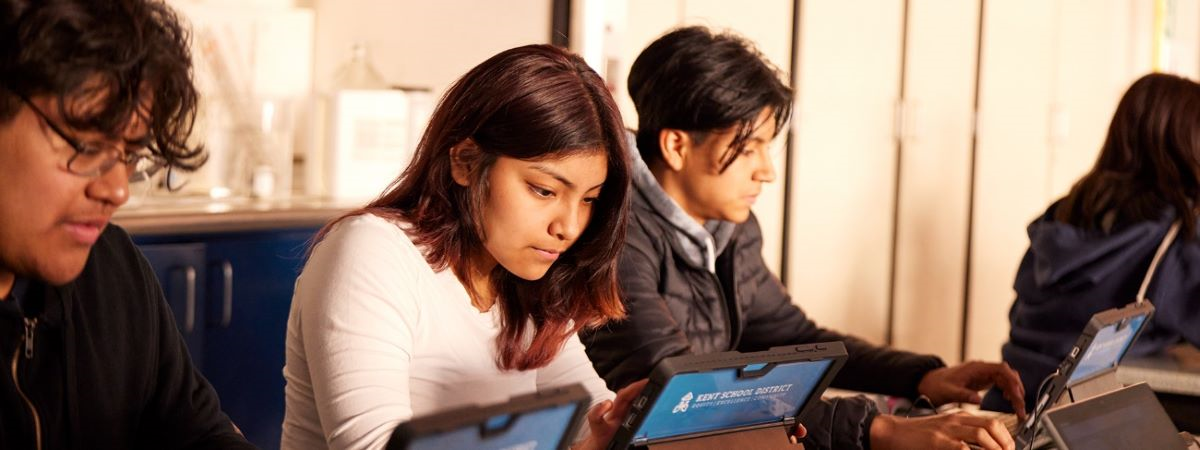 Photo of students engrossed in their studies using tablets with focus and teamwork evident as they navigate educational content.