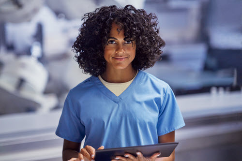 Photograph showing healthcare worker holding a tablet.