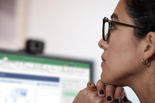 Photograph showing medical professional looking at computer screen.