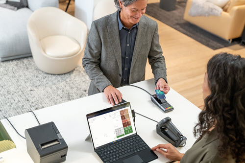 Photograph showing customer paying with a credit card.