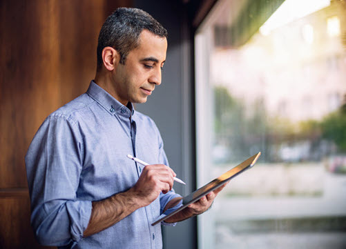 Photograph showing a business user working with Azure AI services on a tablet.