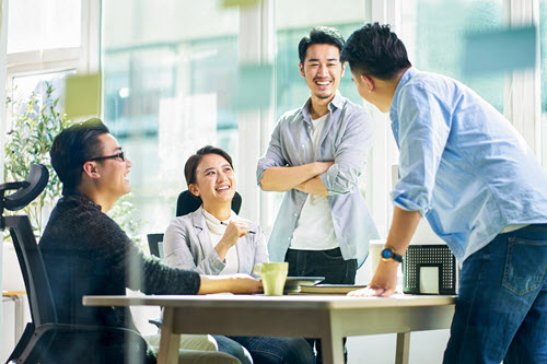 Fotografía que muestra a personas manteniendo conversaciones en una reunión del equipo.