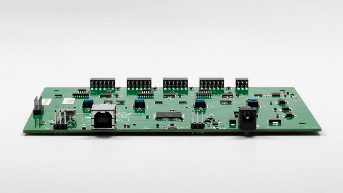 Vista lateral angular de la placa de circuito Traduci que muestra puertos USB y de alimentación.