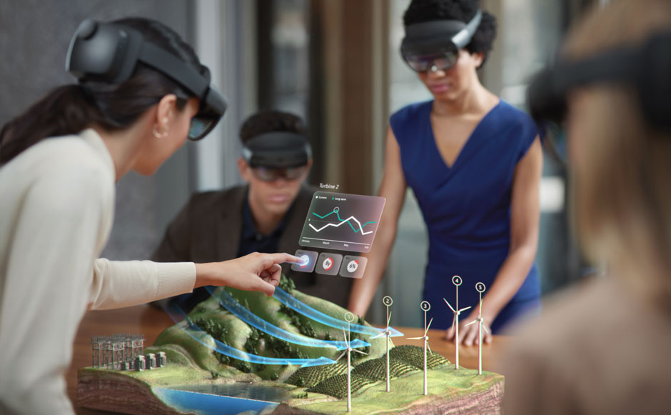 Photo de plusieurs utilisateurs portant des casques HoloLens et se tenant autour d’un affichage holographique et d’un menu interactif au-dessus d’une table.