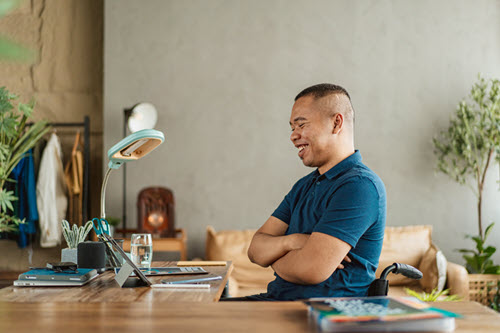 Photographie montrant une personne souriante à un bureau.