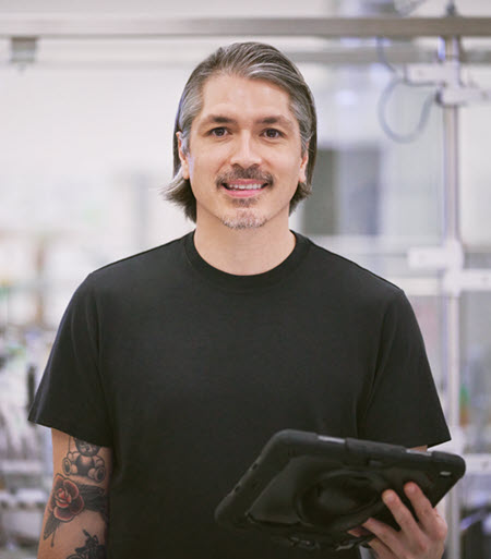 Photographie montrant un homme dans le secteur de la fabrication tenant une tablette.