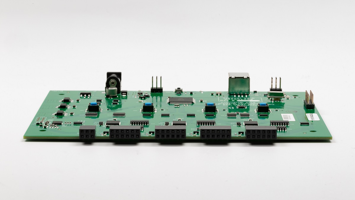 Photo d’une carte de circuits imprimés Traduci avec quatre ports à 12 broches étiquetés JA, JB, JC et JD.