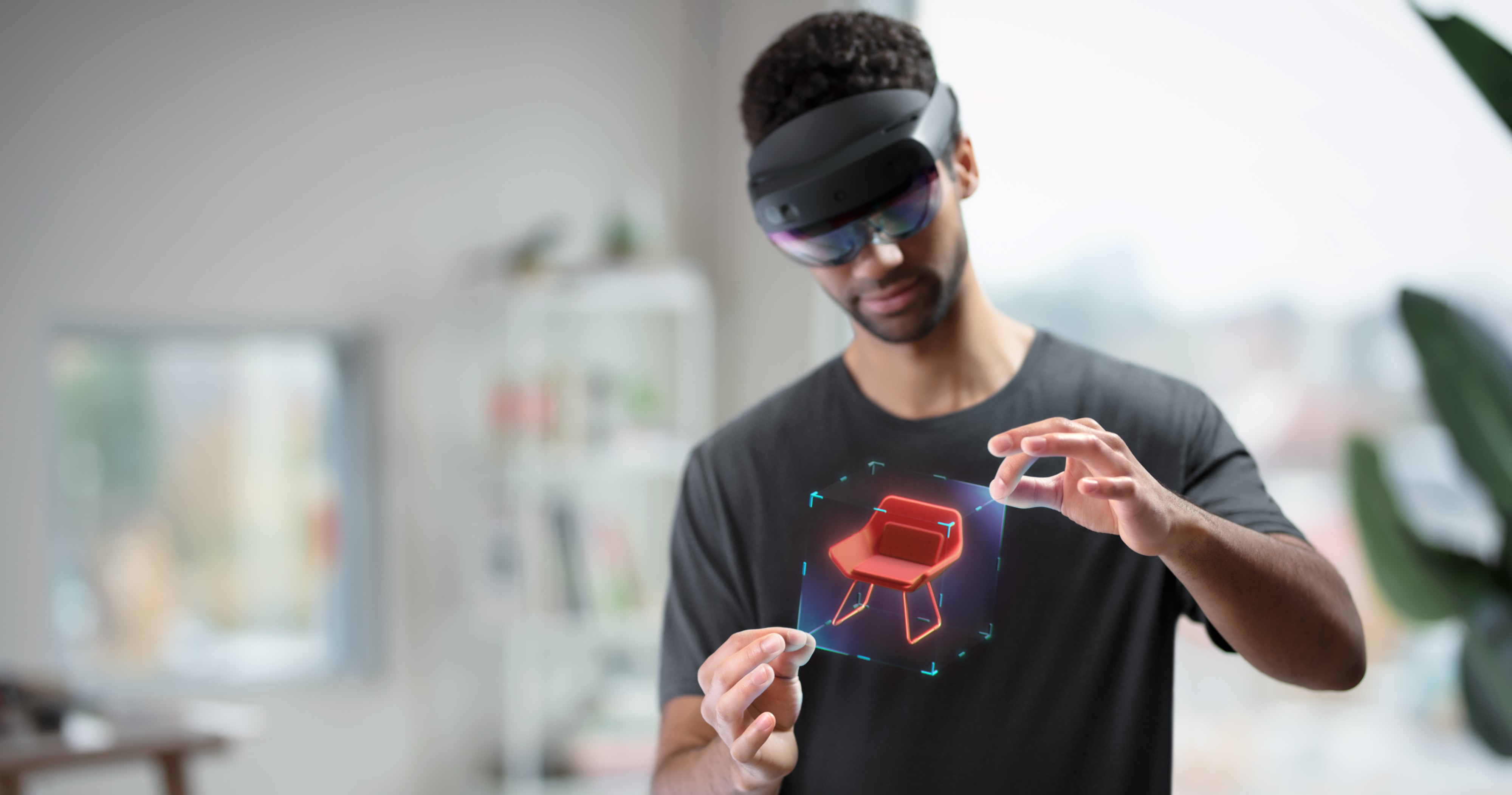 Afbeelding van een gebruiker die een HoloLens draagt en een hologram bewerkt met handbeweging