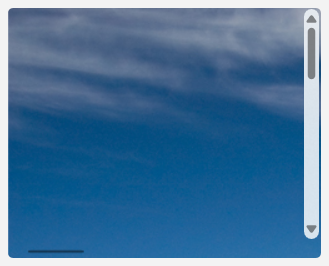 A picture of a mountain zoomed in so far that only blue sky and clouds in the upper left of the picture are visible.