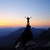 Miniatura da montanha ao ar livre ao pôr do sol, com a silhueta de uma pessoa