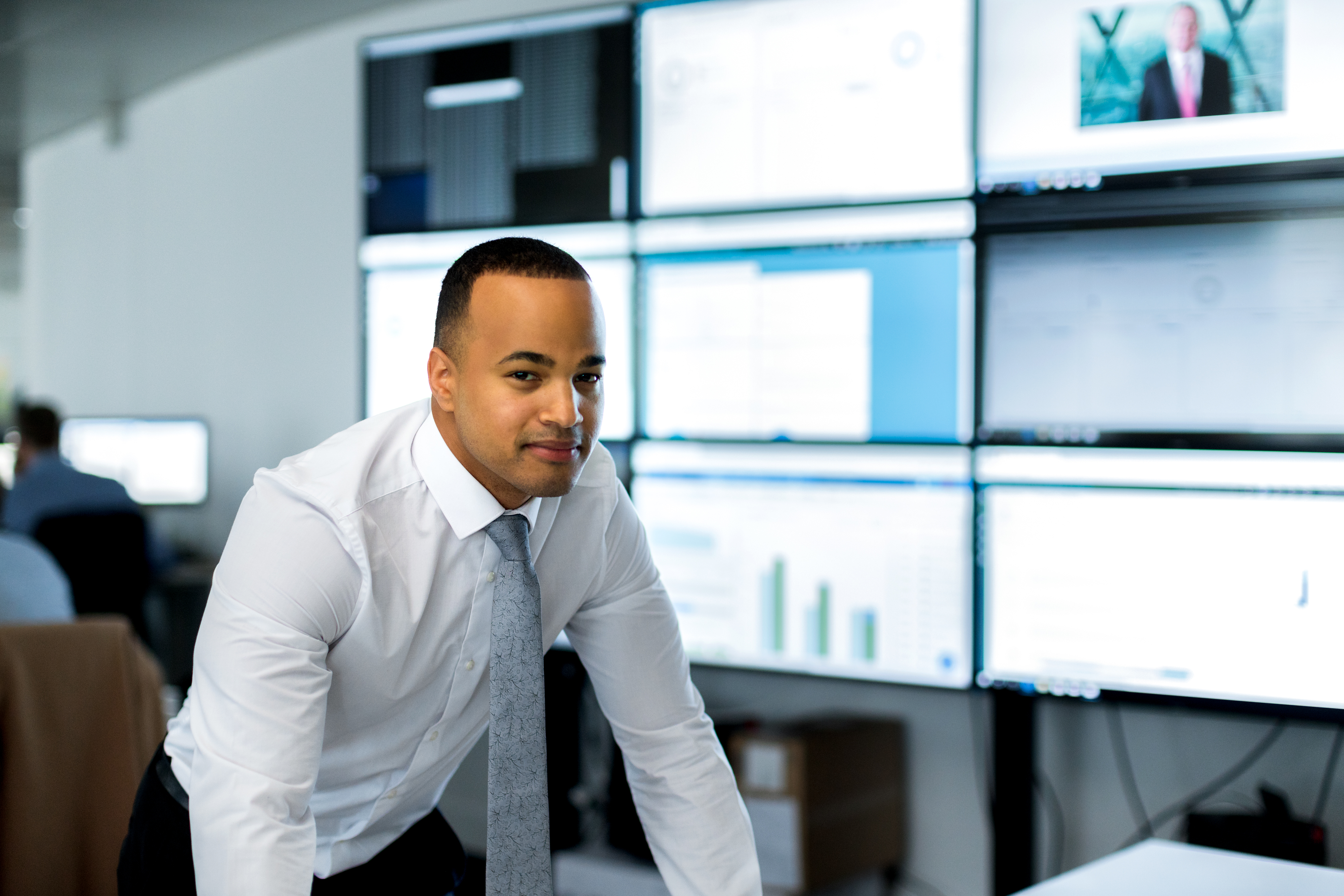 Um técnico de informação é representado em frente a uma grande variedade de monitores.