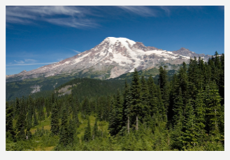 A picture of a mountain zoomed out so that the foreground, mountain, and sky are all visible.